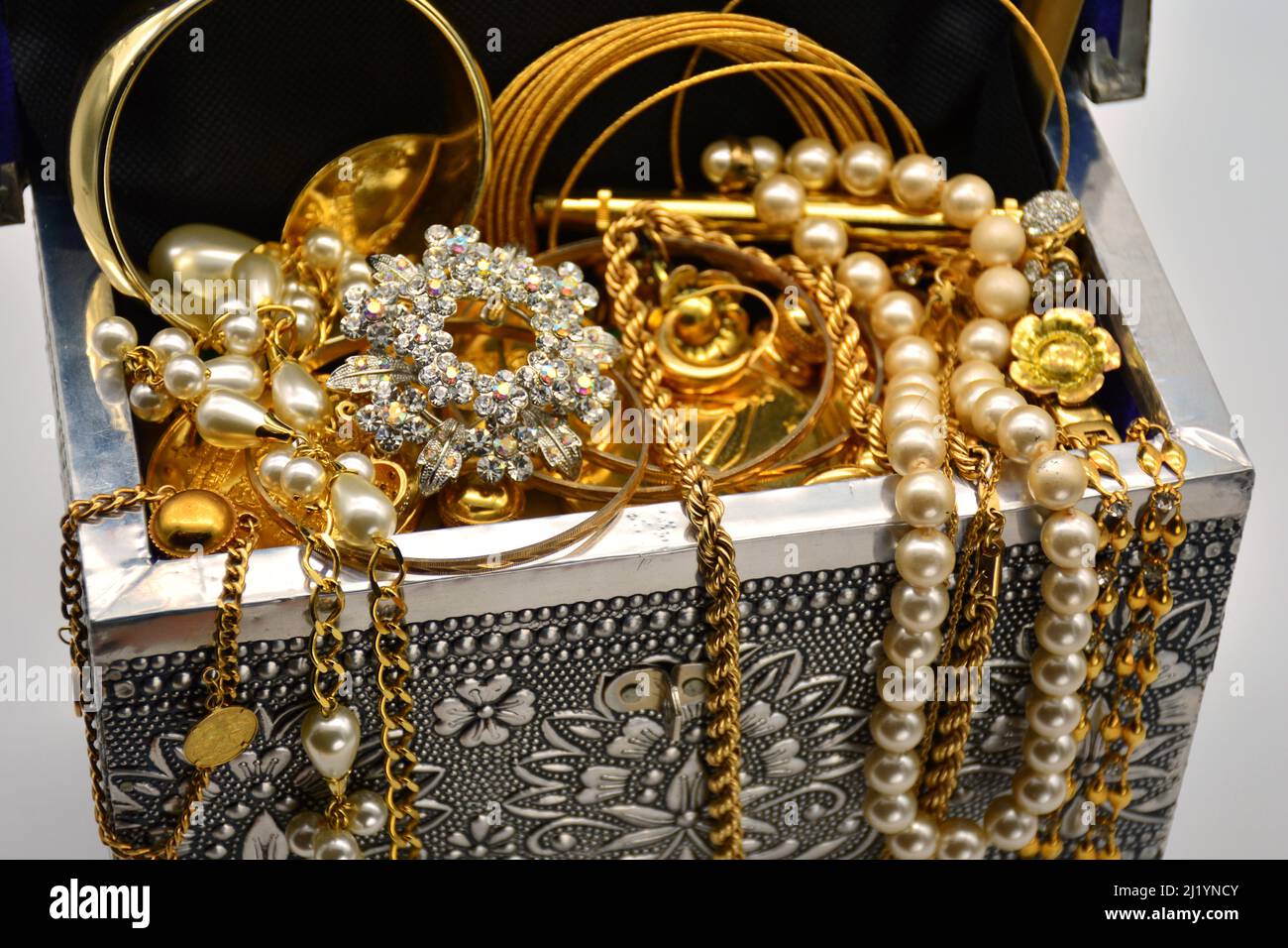 Un tesoro, cofre leno de joyas, perlas, y oro, sobre fondo blanco Foto Stock