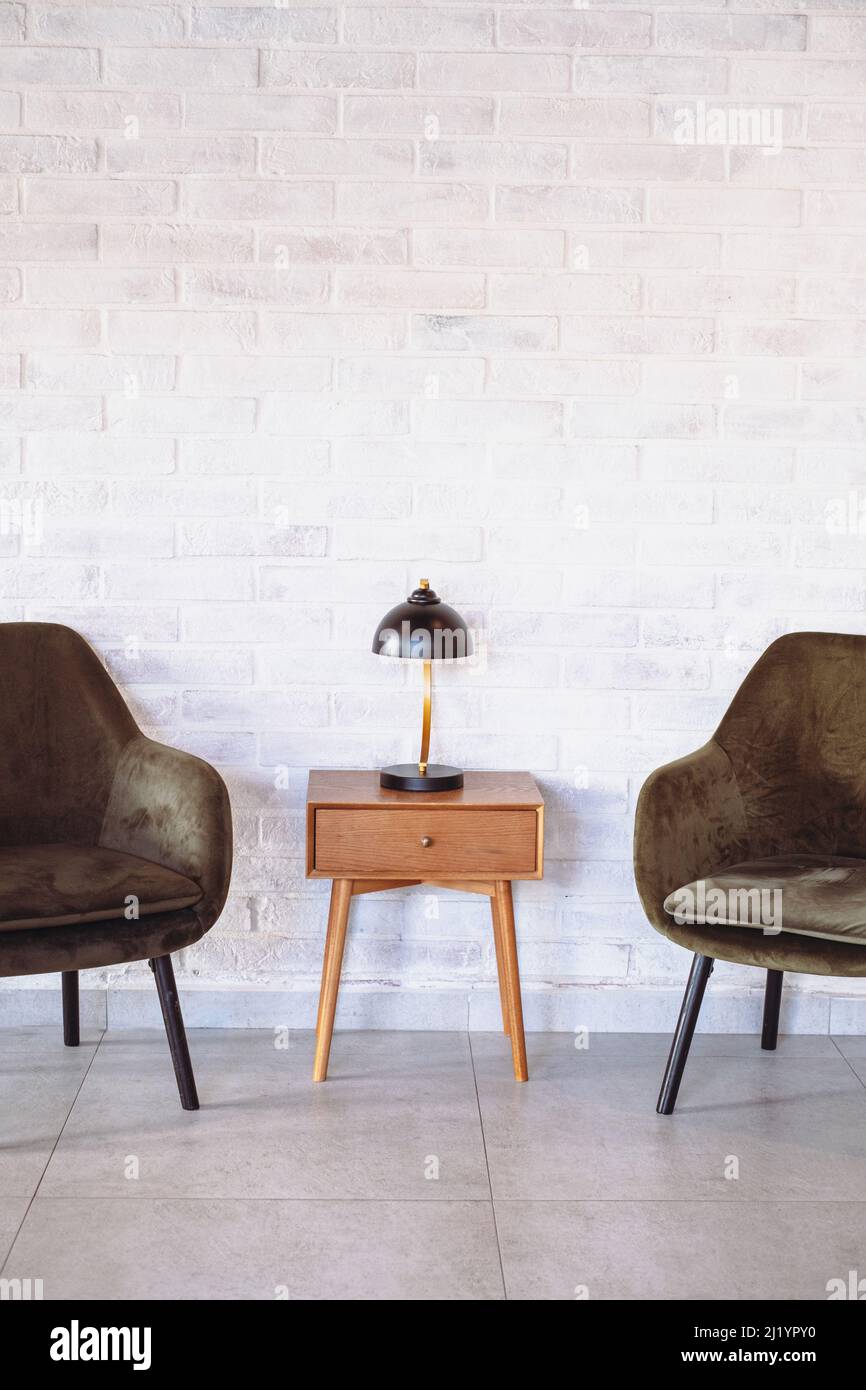 interior design parete in mattoni bianchi due poltrone grigie Foto Stock