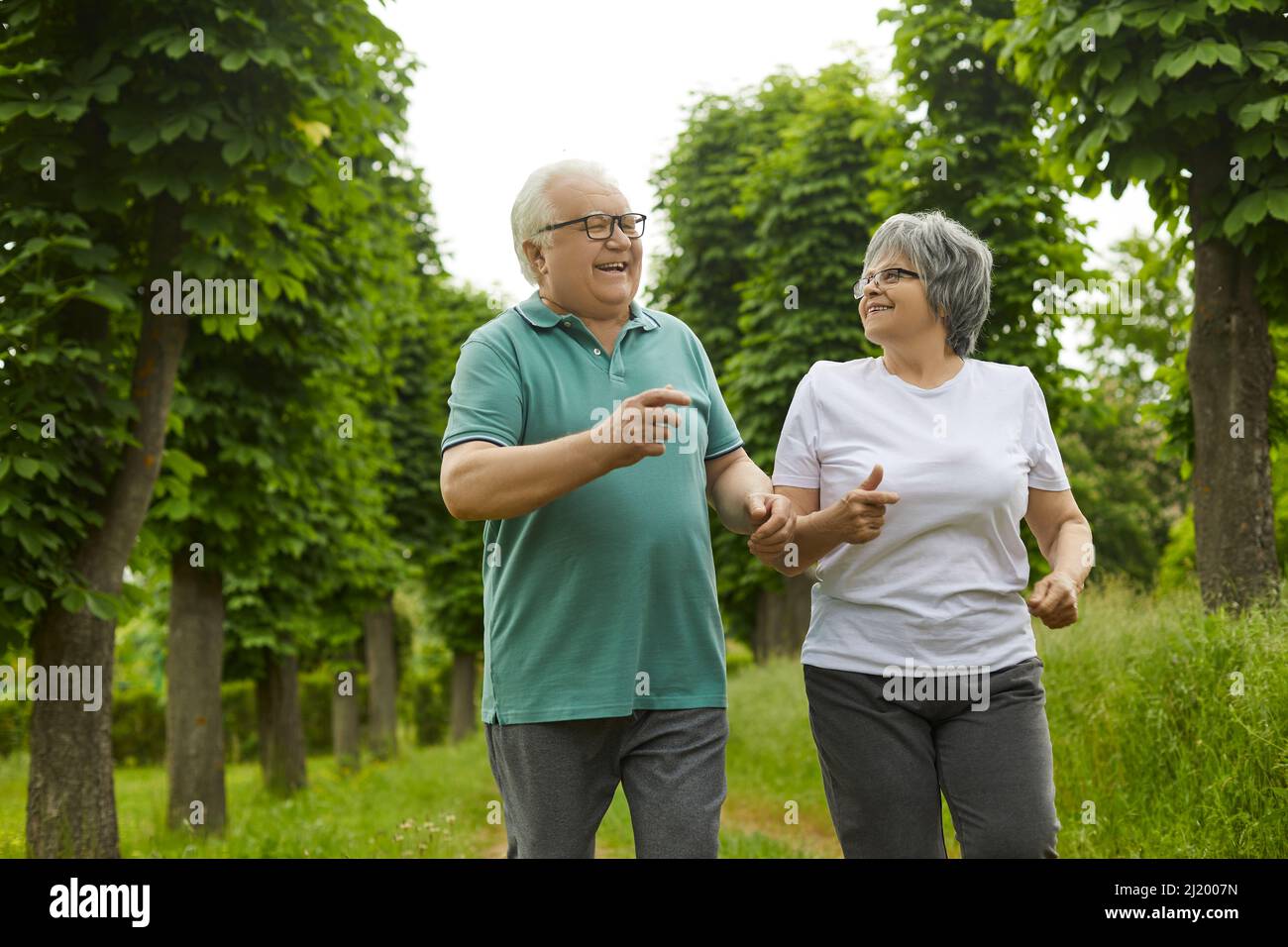 Attivo sano allegro sorridente senior pensionato coppia jogging nel parco verde Foto Stock