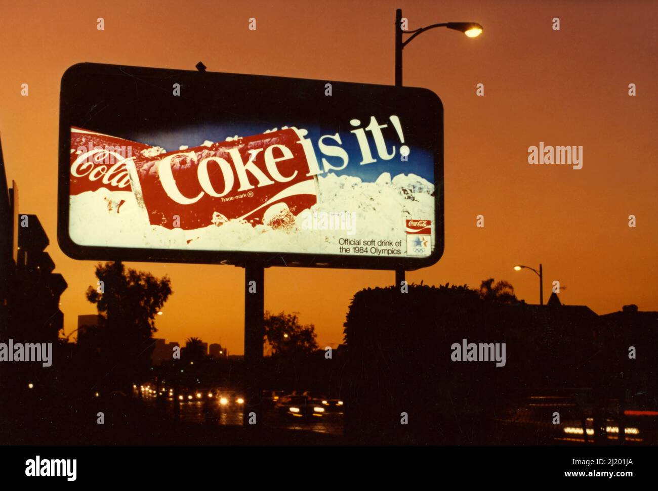 Un tabellone retroilluminato mostra un annuncio per Coca Cola è visto al tramonto di Los Angeles, CA circa 1984. Foto Stock