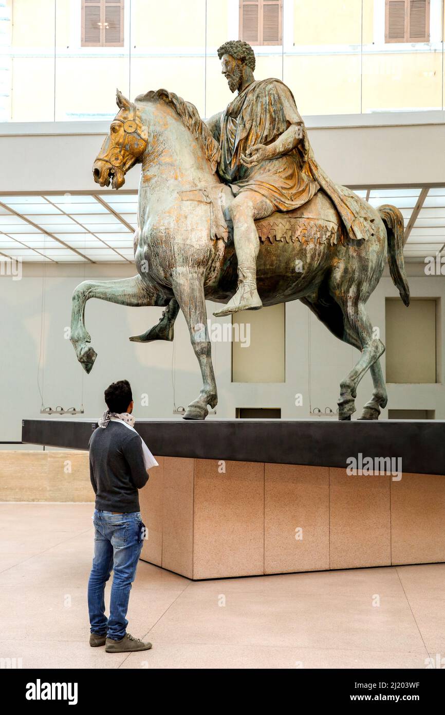 Italia. Roma. Uomo che ammira la statua equestre di Marco Aurelio in piedi nel Museo Palazzo dei Conservatori di Roma. Foto Stock