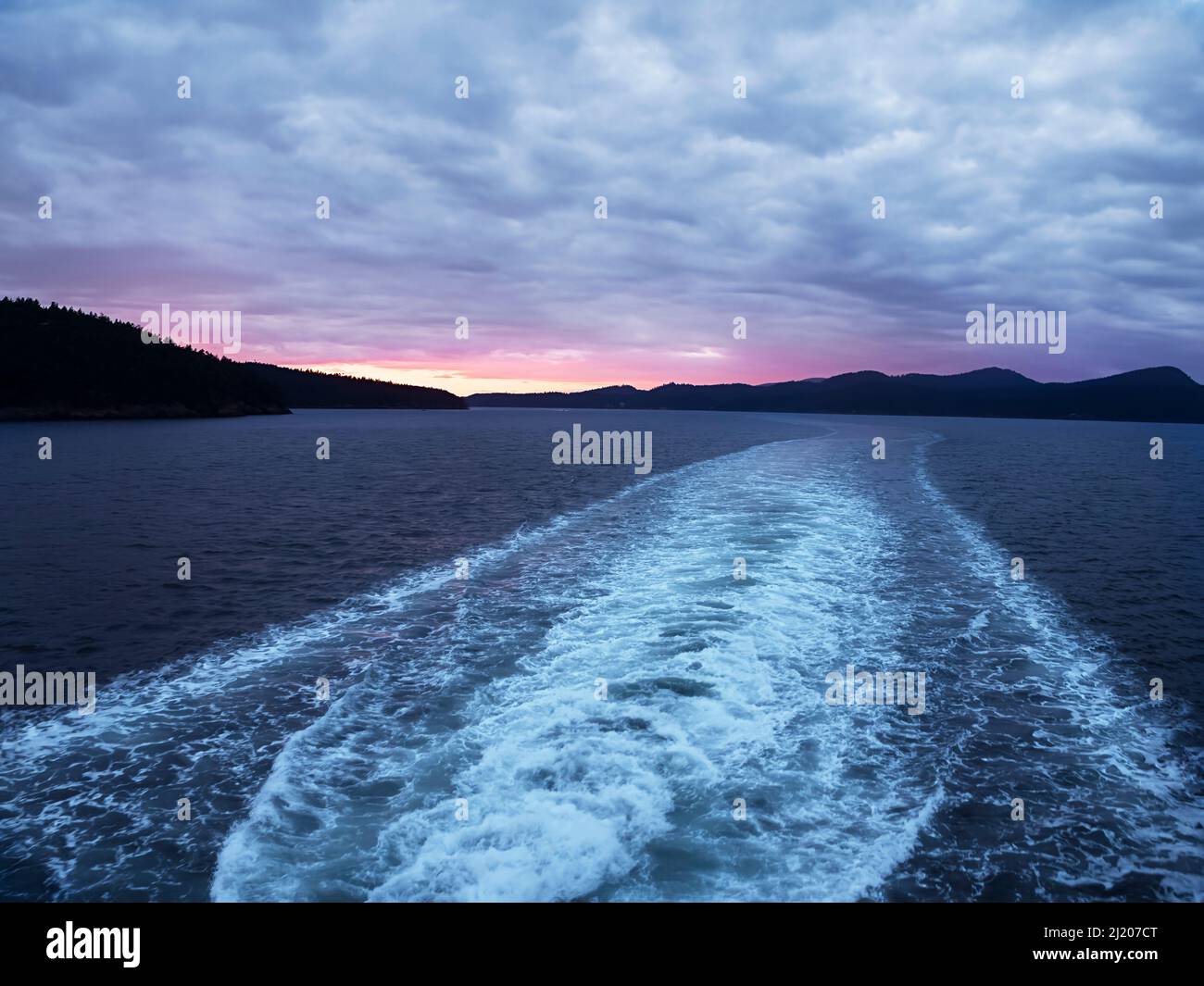 WA21209-00...WASHINGTON - Vista del tramonto dal traghetto che lascia l'Isola di San Juan e si dirige verso la terraferma ad Anacortes. Foto Stock
