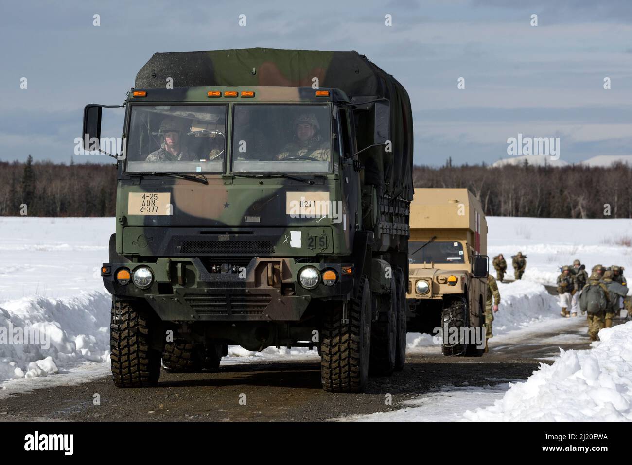 I veicoli militari partono dalla Malemute Drop zone dopo aver completato l'addestramento aereo alla Malemute Drop zone, Joint base Elmendorf-Richardson, Alaska, 24 marzo 2022. Le unità dell'esercito e dell'aeronautica si allenano regolarmente per rafforzare e mantenere le capacità di preparazione missionaria in un ambiente artico. (STATI UNITI Air Force foto di Alejandro Peña) Foto Stock