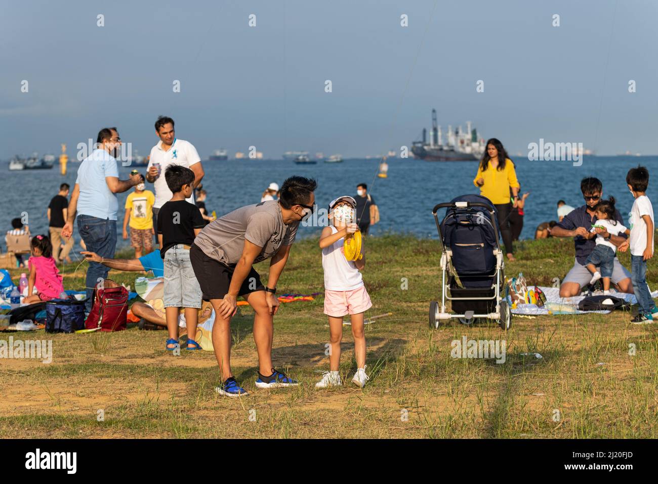 Singapore, Singapore. 26th Mar 2022. Persone che indossano maschere per il viso come misura preventiva contro la diffusione di Covid-19 visto avere un pic-nic e aquilone volare a Marina Barrage, Singapore. (Foto di Maverick Asio/SOPA Images/Sipa USA) Credit: Sipa USA/Alamy Live News Foto Stock