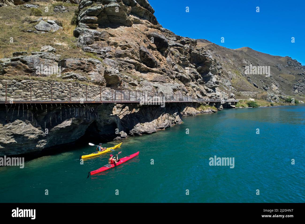 Kayak da ponte a sbalzo sul percorso ciclabile del lago Dunstan, lago Dunstan, vicino a Cromwell, Otago centrale, Isola del Sud, Nuova Zelanda - antenna drone Foto Stock