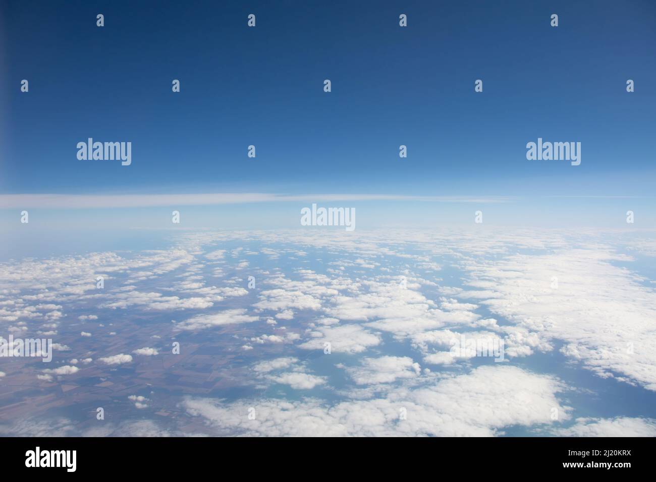 Nuvolosità sulla superficie terrestre da un'altezza durante un volo in aereo Foto Stock