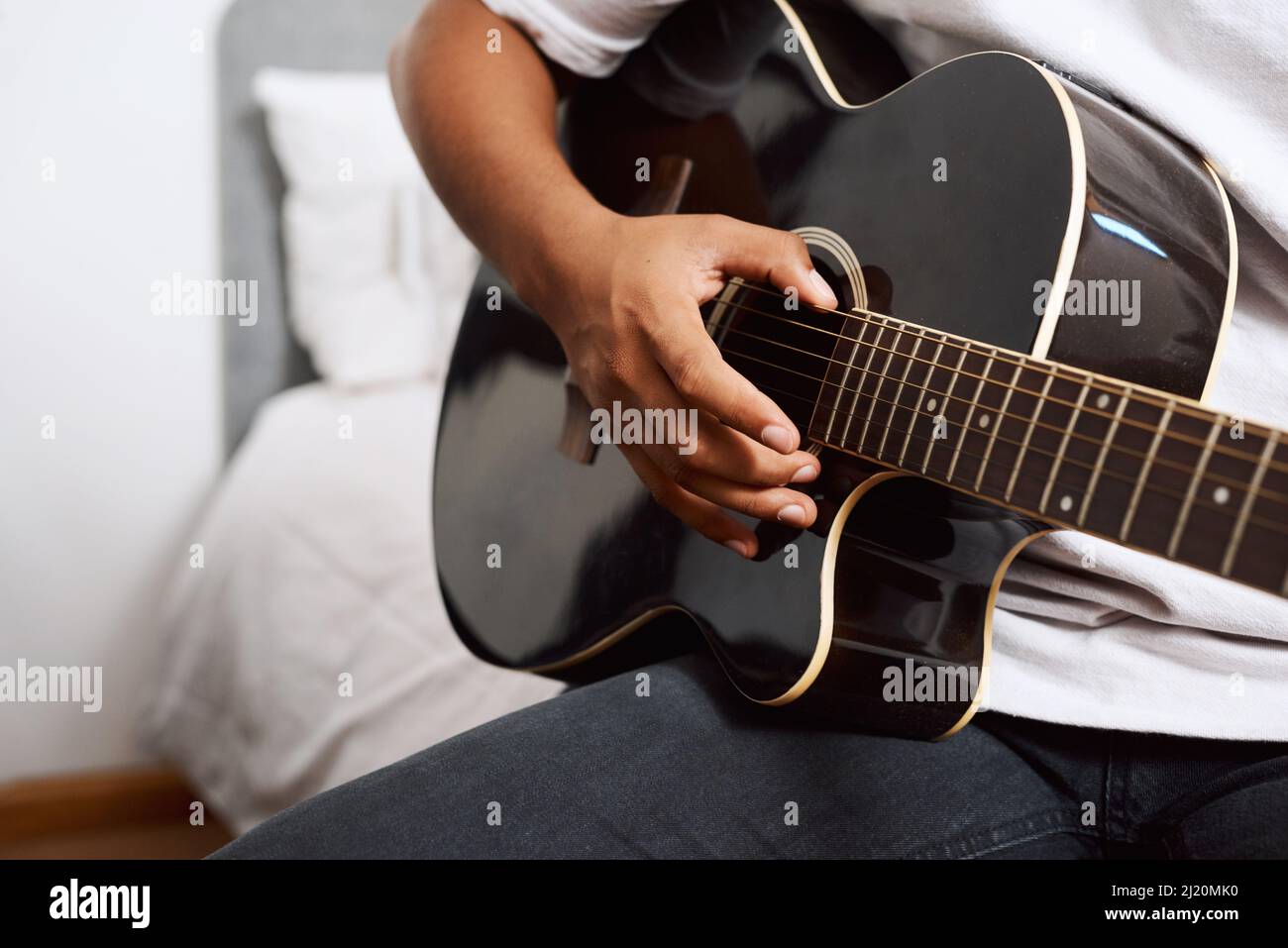 È un ottimo modo per esprimersi. Scatto di un giovane che suona la chitarra mentre si siede a casa. Foto Stock