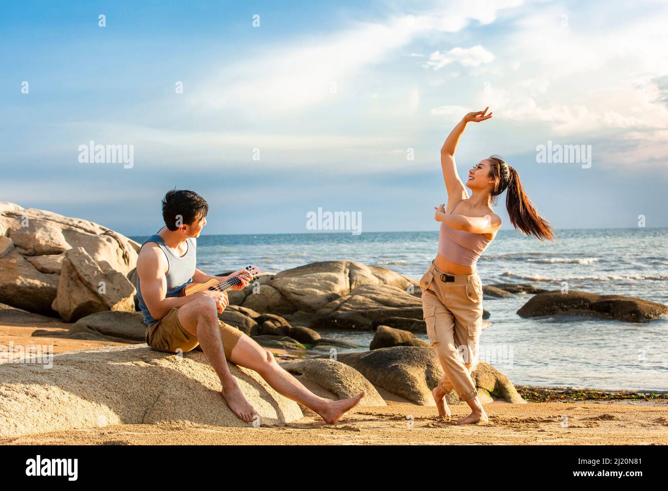 Sposi che si godono la loro luna di miele alla spiaggia sotto il sole estivo - foto di scorta Foto Stock