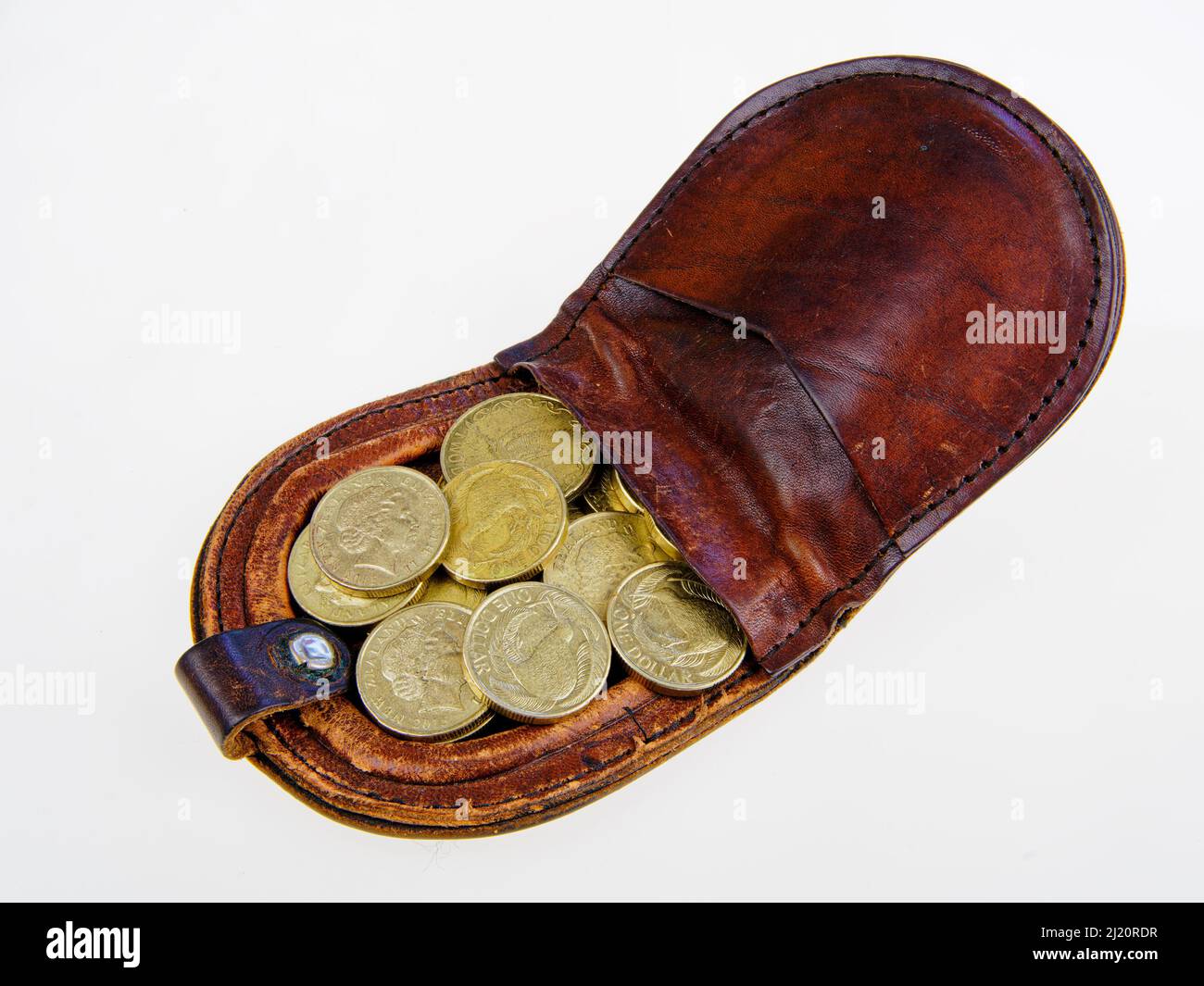 Nuova Zelanda 26 marzo 2022: Monete della Nuova Zelanda, un sacco di monete da un dollaro e due dollari in una borsa di cambio di pelle su sfondo bianco. Foto Stock