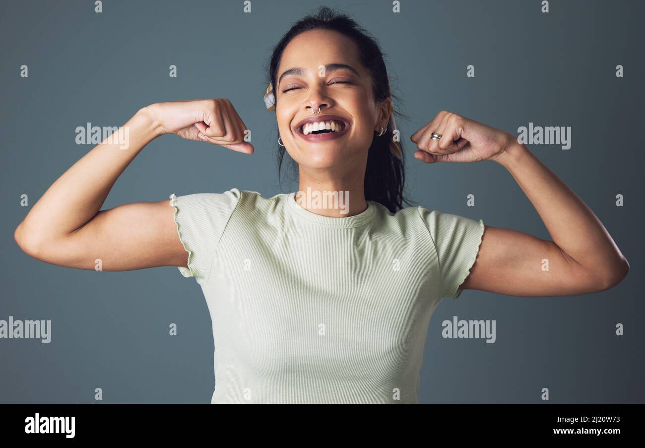 Sì im una femmina e no im non debole. Studio girato di una giovane donna che si flette su uno sfondo grigio. Foto Stock