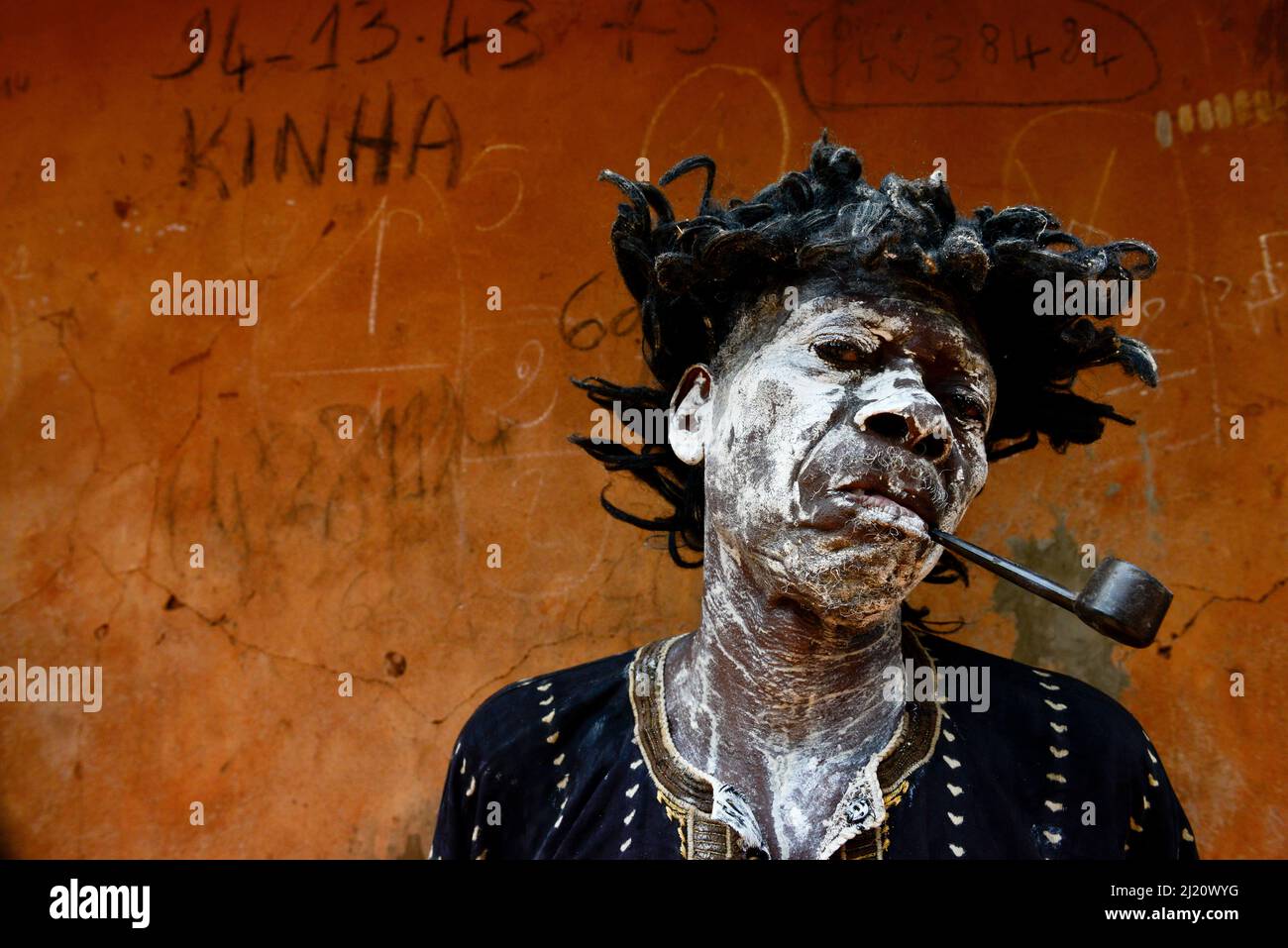Un uomo rappresenta un personaggio malato e fumante, in una cerimonia voodoo nel villaggio di Bohicon, Benin. Gennaio 2020 Foto Stock