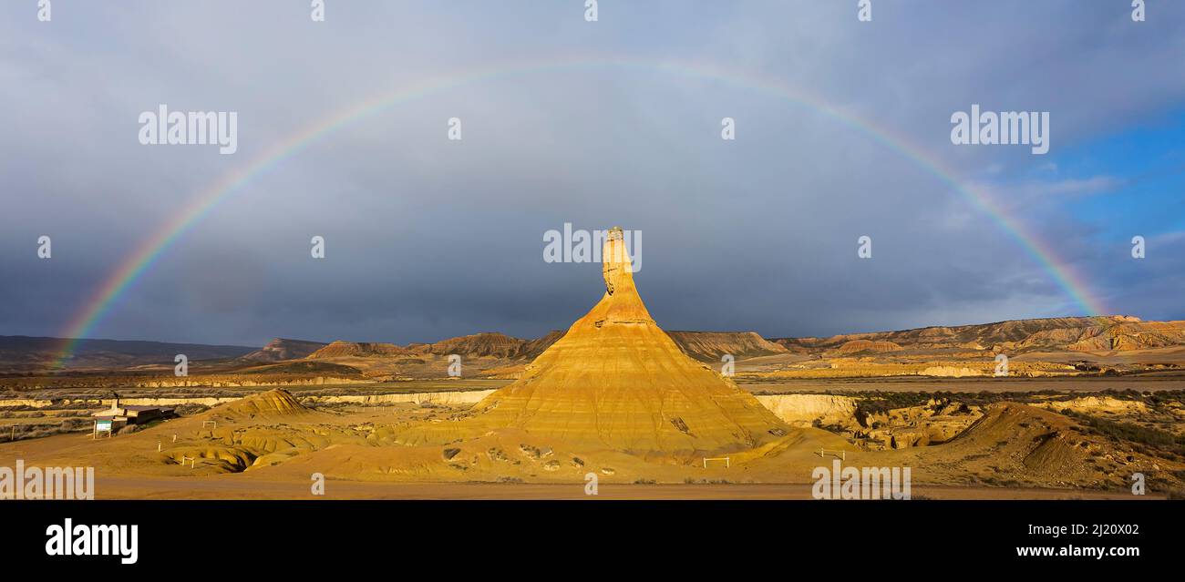 Arcobaleno sopra i badlands e la formazione di roccia di montagna di Castildetierra. Parco Naturale delle Bardenas Reales. Navarra, Spagna. Febbraio 2015. Foto Stock