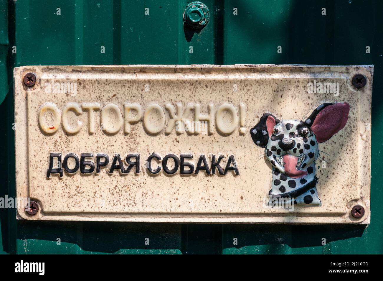 Kiev, Ucraina - 3 luglio 2021: Un cartello appluso sulla recinzione di fronte ad una casa suburbana. Il cartello recita 'attenzione! Cane gentile. C'è un disegno di un cane Foto Stock
