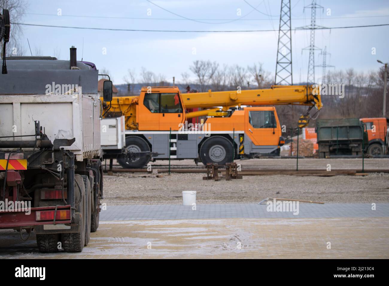 Autocarro per impieghi gravosi e gru di sollevamento mobile in cantiere. Foto Stock