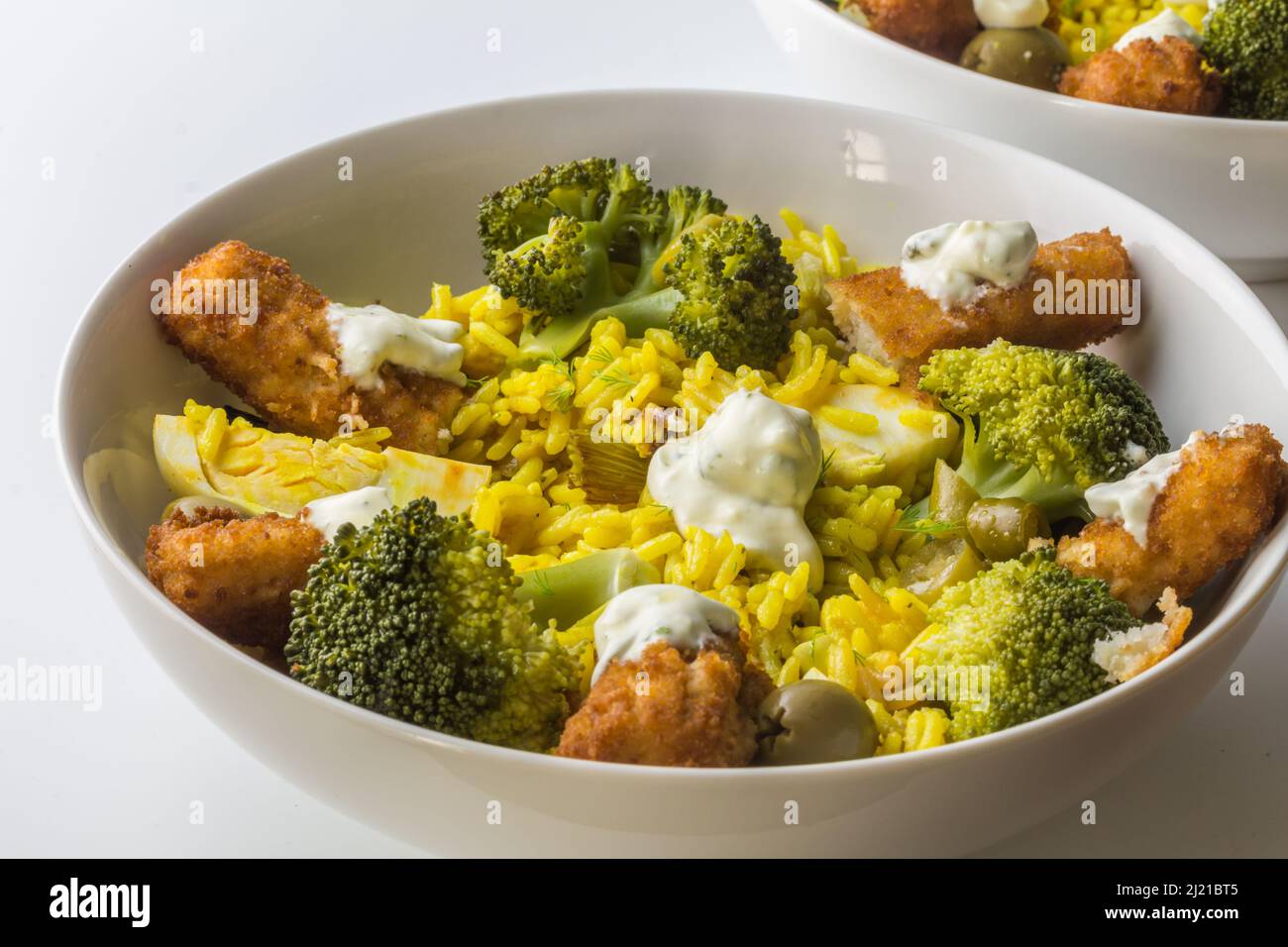 Dita di pesce con riso giallo e broccoli - ricetta rustica e ricca con bastoncini di pesce con fuoco selettivo Foto Stock
