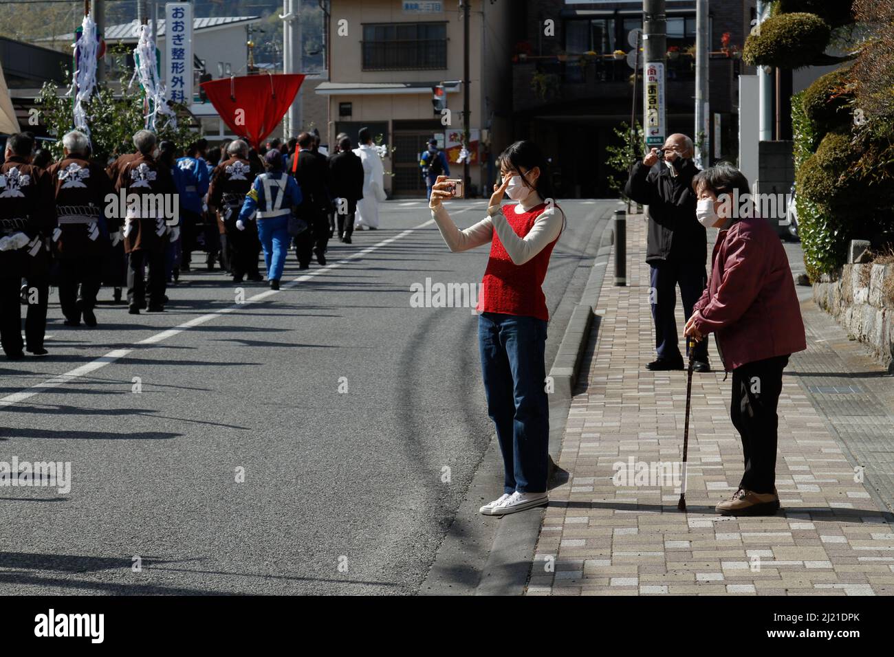 iida, nagano, giappone, 2022/24/03 , persone che scattano foto alla processione religiosa carrando il mikoshi, nella città di iida. Un mikoshi è un religioso sacro Foto Stock