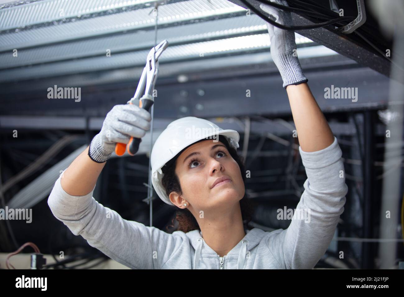 Donna al lavoro su soffitto Foto Stock