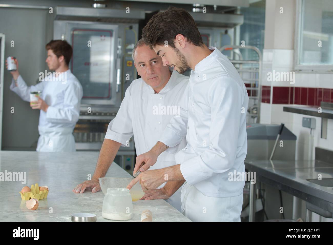 chef pasticceria e assistenti di fare una torta Foto Stock