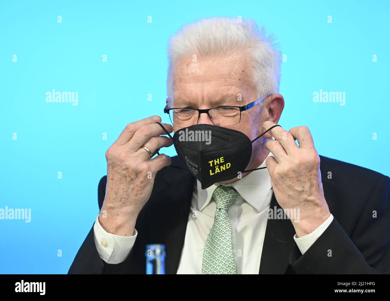 Stoccarda, Germania. 29th Mar 2022. Winfried Kretschmann (Bündnis 90/Die Grünen), Ministro Presidente del Baden-Württemberg, mette in maschera la sua protezione durante una conferenza stampa del governo al parlamento di Stato di Stoccarda. Sul suo lapel indossa un piccolo perno a forma di bandiera Ucraina. Credit: Bernd Weißbrod/dpa/Alamy Live News Foto Stock