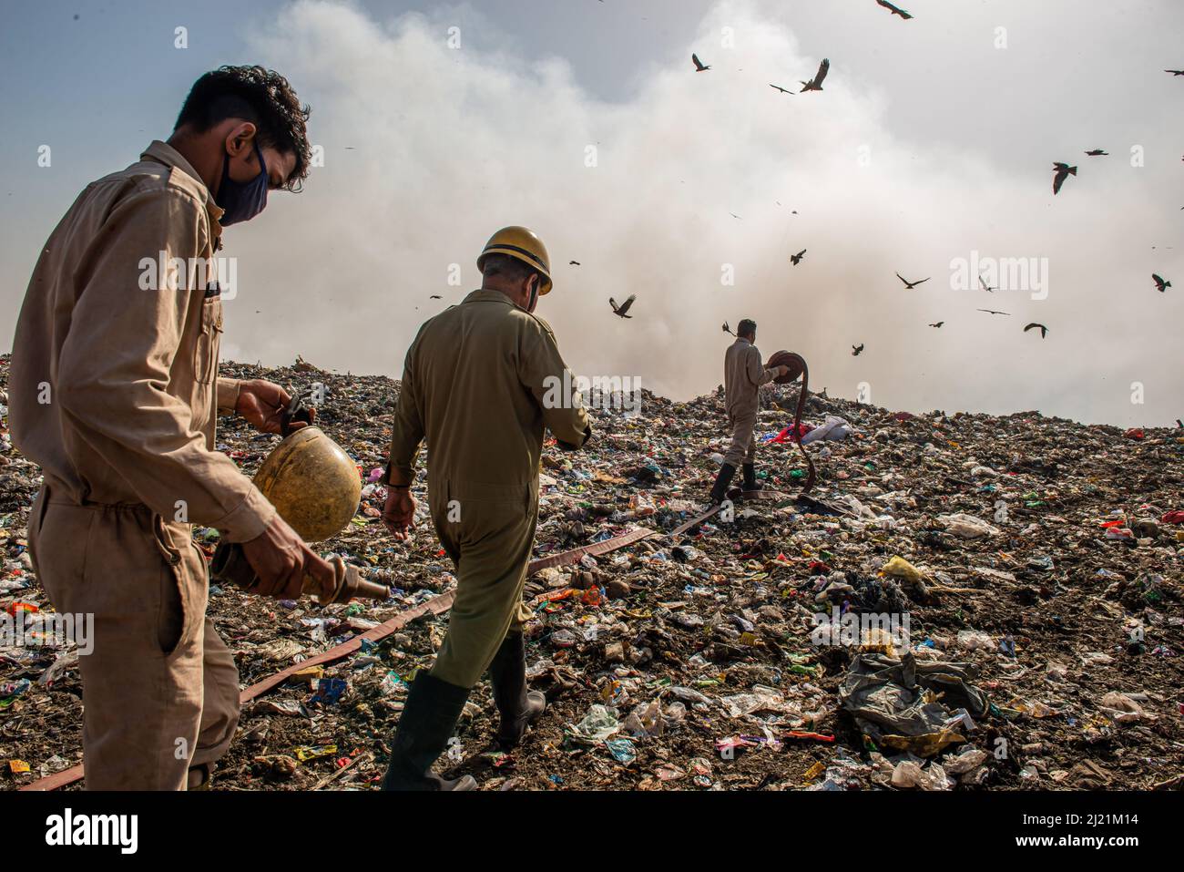 New Delhi, India. 29th Mar 2022. Delhi Vigili del fuoco che posano il tubo che prova a controllare il fuoco alla discarica di Ghazipur, Nuova Delhi. L'incendio si diffuse in diverse pile di rifiuti in pochi minuti, i funzionari antincendio hanno dichiarato che "materiale altamente combustibile" e il fumo costituivano una sfida nelle operazioni di estinzione degli incendi. Il sito di discarica di Ghazipur è stato uno dei più grandi siti di discarica per Delhi. La discarica è cresciuta negli ultimi anni. (Foto di Pradeep Gaur/SOPA Images/Sipa USA) Credit: Sipa USA/Alamy Live News Foto Stock