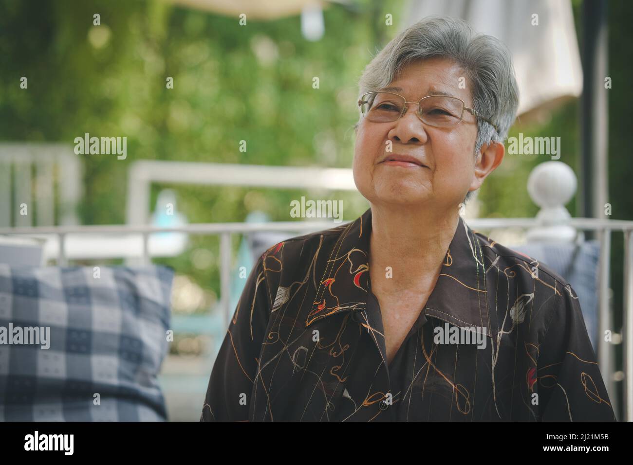 anziana anziana donna anziana che riposa rilassante in giardino Foto Stock