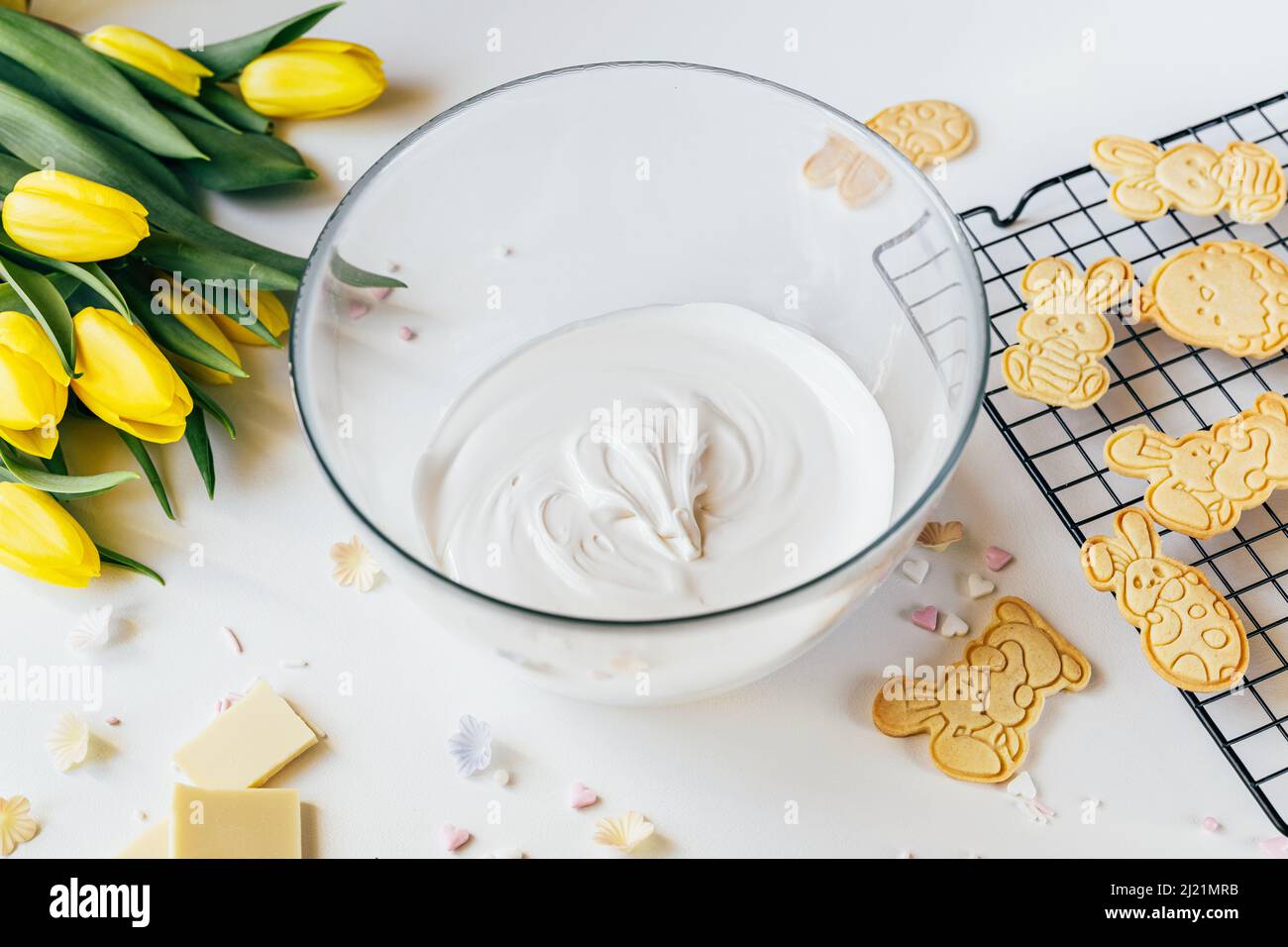 Ciotola di vetro con glassa bianca biscotto per decorazione. Vacanze di Pasqua sostegno Foto Stock
