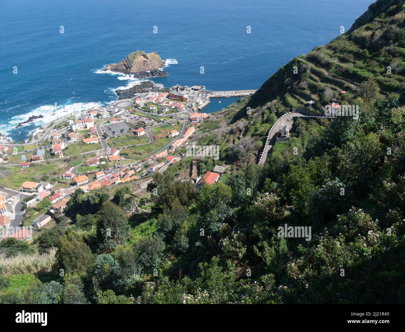 Guardando verso il basso per l'incantevole Porto Moniz, un'affascinante cittadina che si affaccia sulla suggestiva punta nord-occidentale di Madeira Portogallo UE da Miradouro da Sant Foto Stock