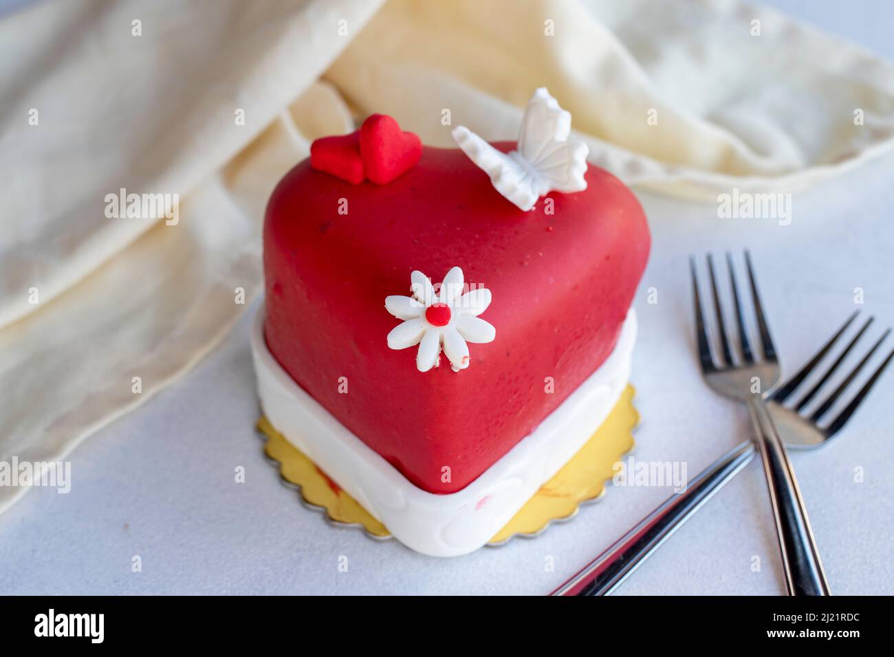 Una torta di rosso a forma di cuore per San Valentino, anniversari e  compleanni. tortine con decorazioni per il giorno di San Valentino Foto  stock - Alamy