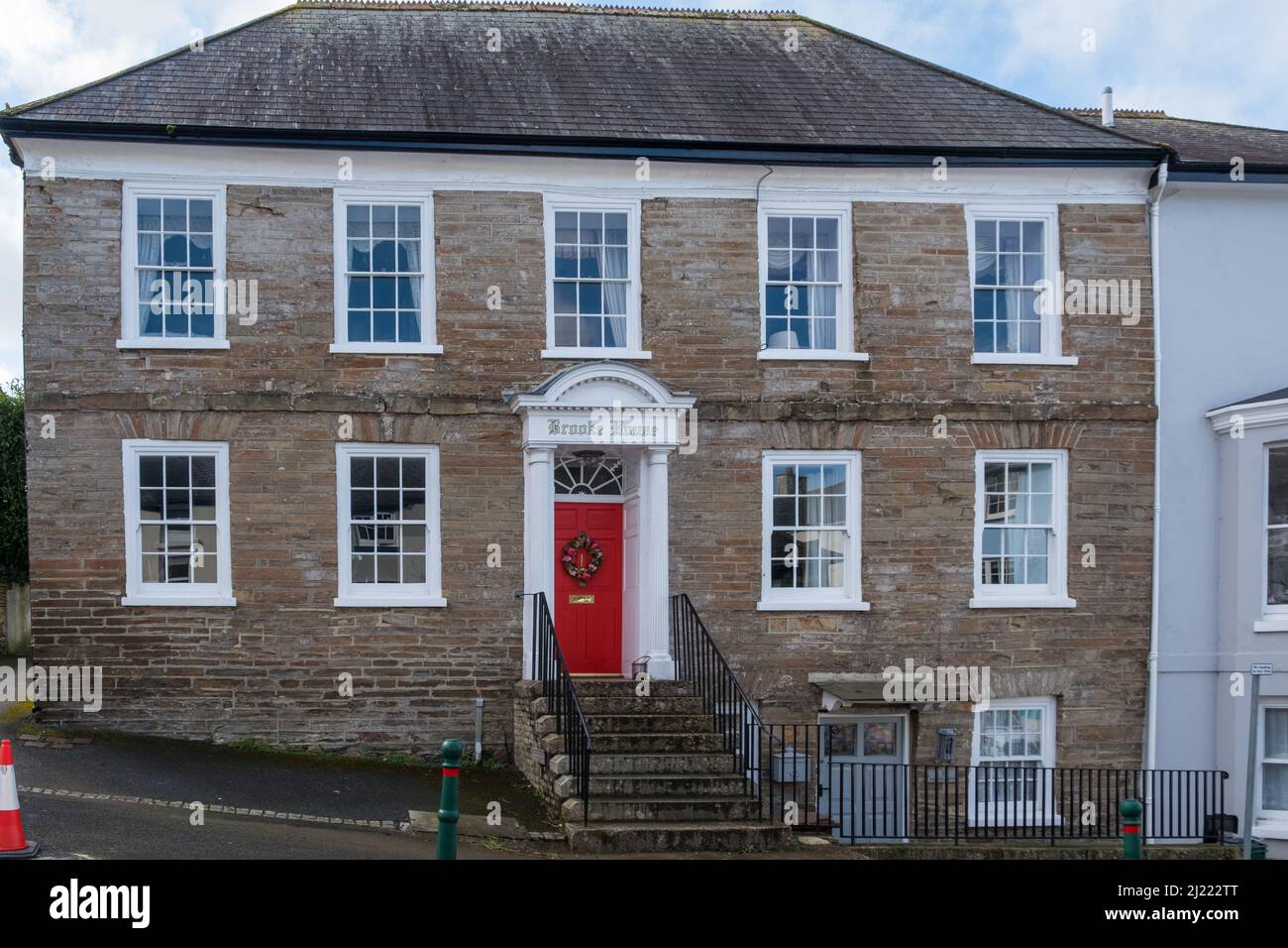 Grande casa in stile georgiano con porta d'ingresso rossa nella città di Modbury, nel Devon di South Hams Foto Stock