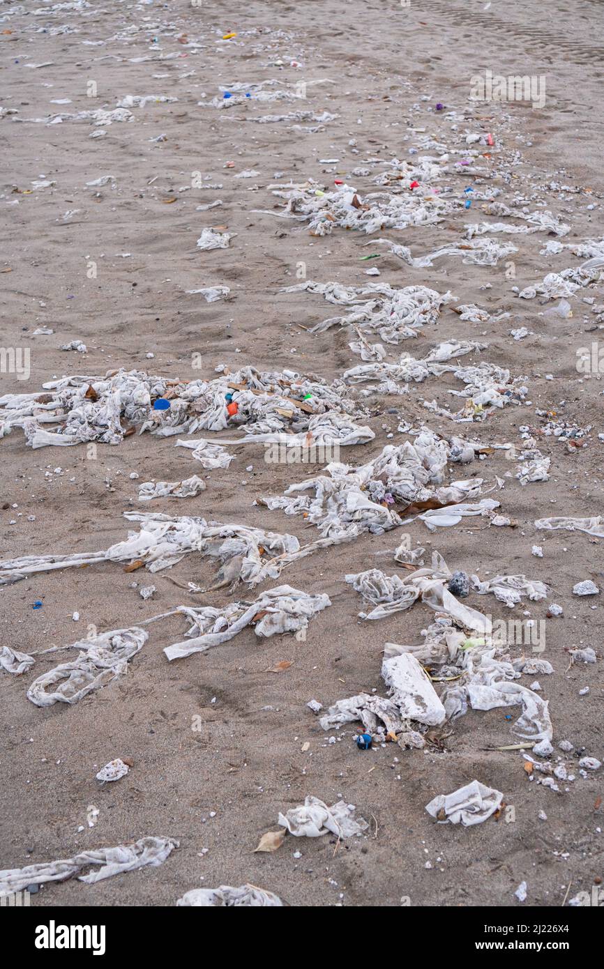 Spiaggia piena di immondizia, salviette bagnate e rifiuti che la gente gettano nella toilette. Concetto di inquinamento oceanico e di distruzione ambientale Foto Stock