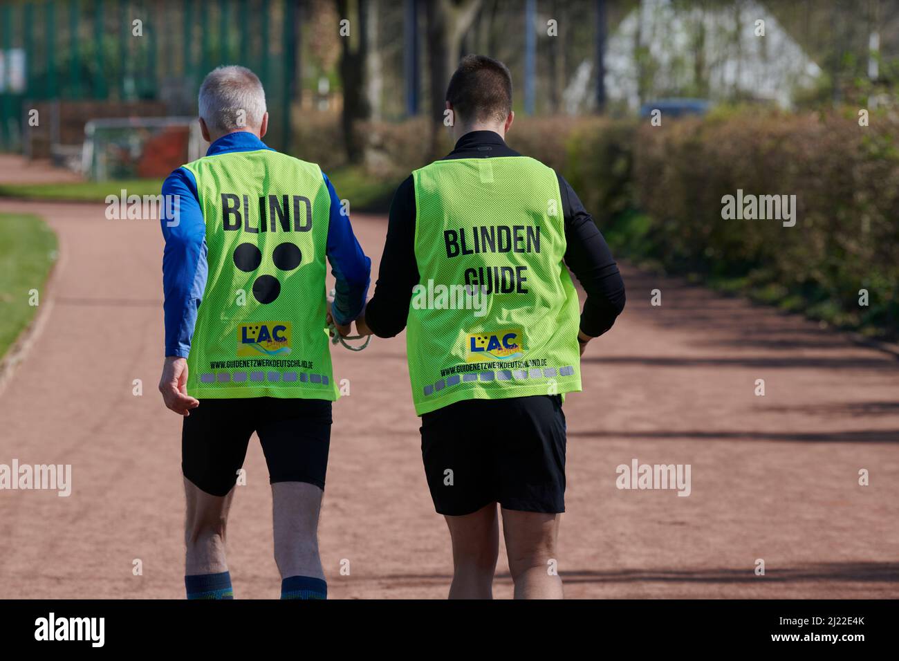 In Mülheim an der Ruhr werden erstmals Laufguides fuer sehbeeintraechtigte und blinde Menschen. Angeboten. Laufguide mit einem sehbehinderten Menschen Foto Stock