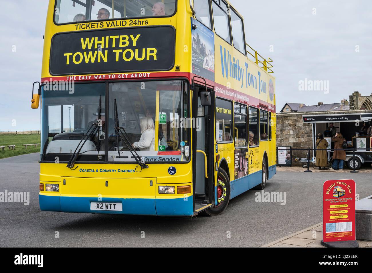 Scenografica Whitby con l'autobus locale Whitby Town Tour all'Abbazia di Whitby, famoso come sfondo e ambientazione del romanzo di Bram Stoker, Dracula Foto Stock