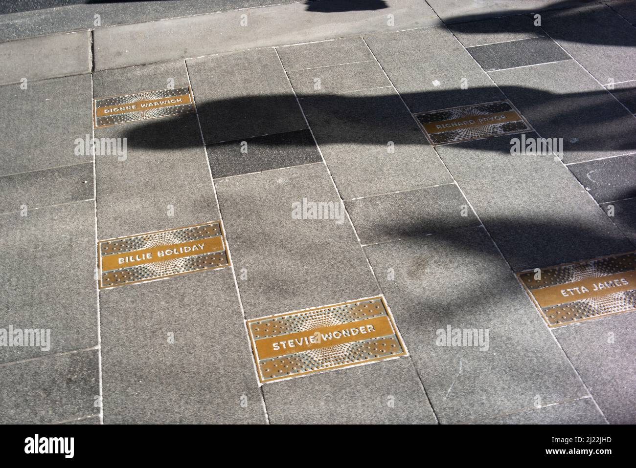 New York, USA ha inciso i nomi dei musicisti afro-americani sul marciapiede sotto il marchese dell'Apollo Theatre di Harlem Foto Stock