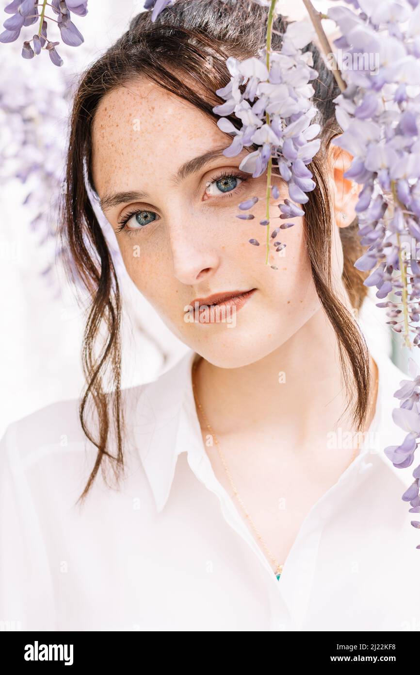 Bella giovane donna circondata da fiori Foto Stock
