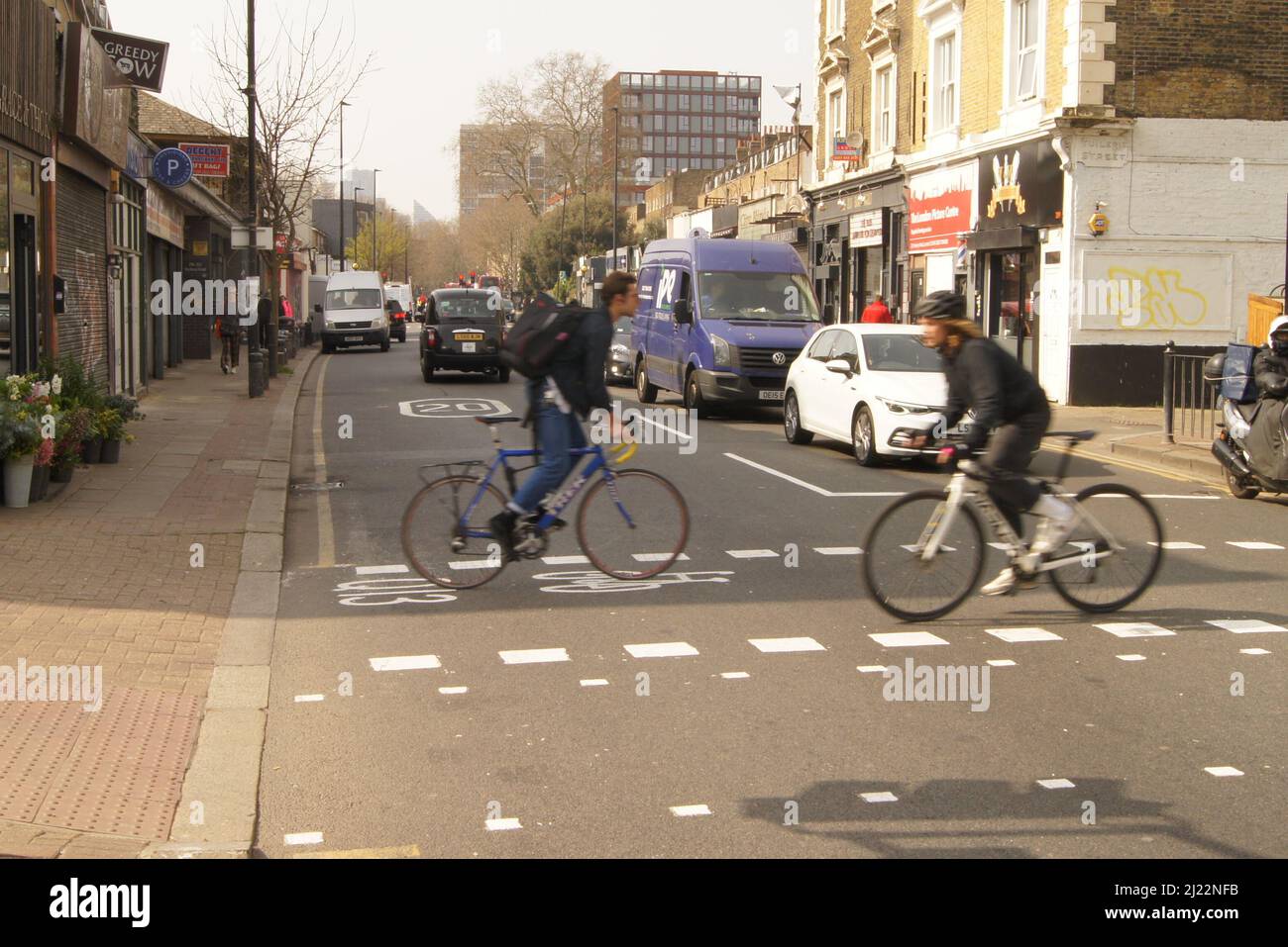 Ciclate attraversando Hackney Road Foto Stock