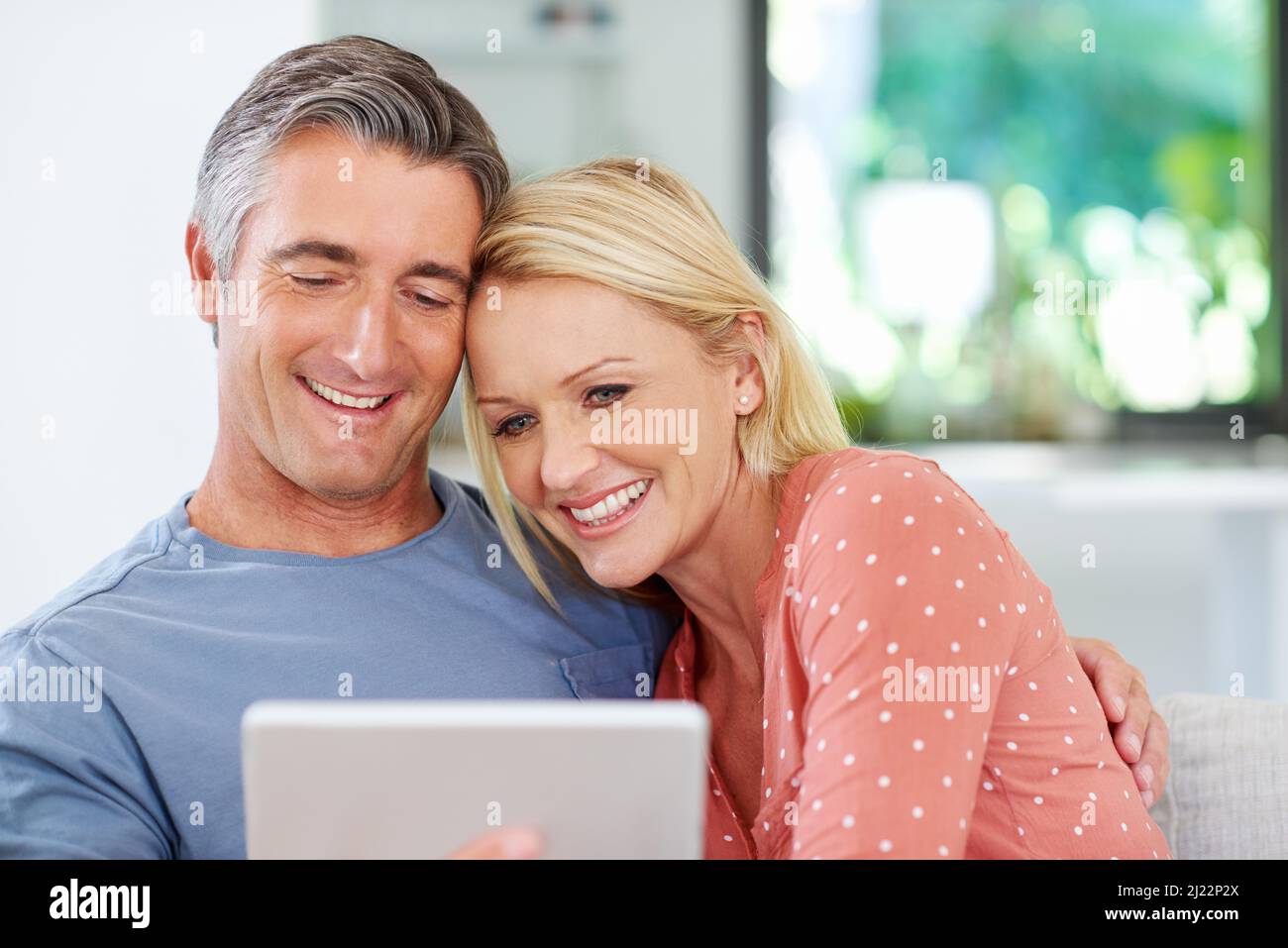Rilassati con un po' di intrattenimento online. Scatto di una coppia matura che si rilassa con il suo tablet digitale a casa. Foto Stock