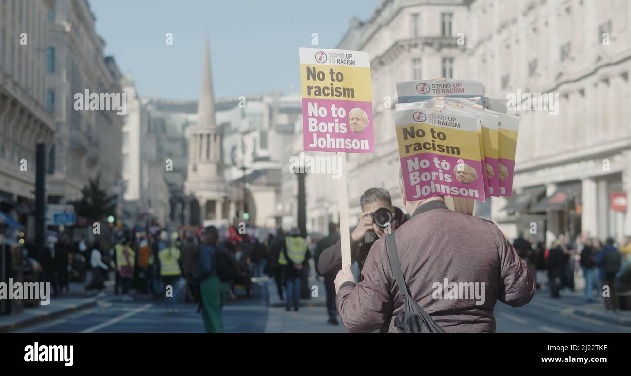 Londra, UK - 03 19 2022: Protesta contro Regent Street, con un cartello, “No al razzismo. No a Boris Johnson’, con una folla di persone sullo sfondo. Foto Stock