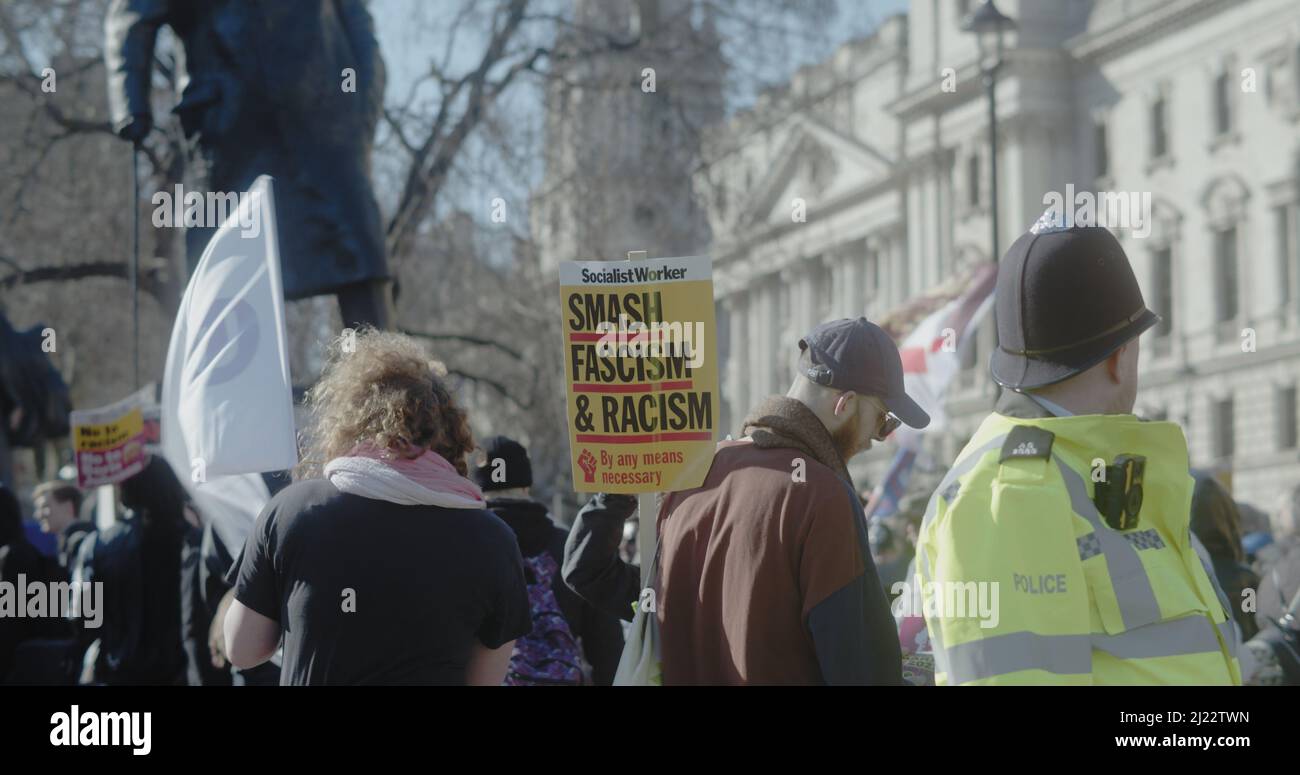 Londra, Regno Unito - 03 19 2022: Un uomo che protestò in Piazza del Parlamento con un cartello, “Smash Fascism and Racism”, per l’annuale “Marca contro il razzismo”. Foto Stock