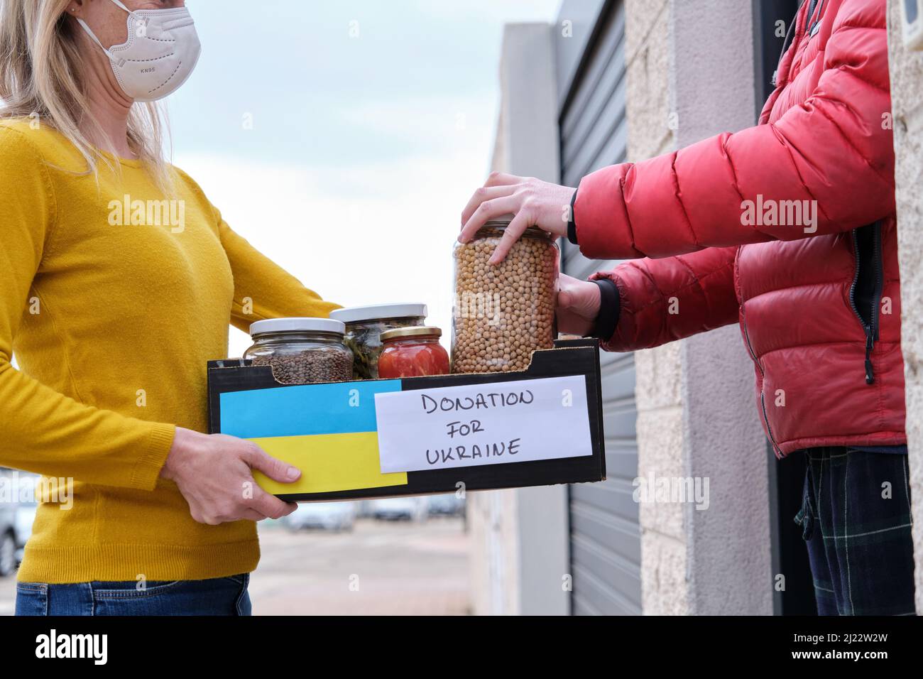 Volontario femminile che consegna donazioni a una persona Ucraina Foto Stock