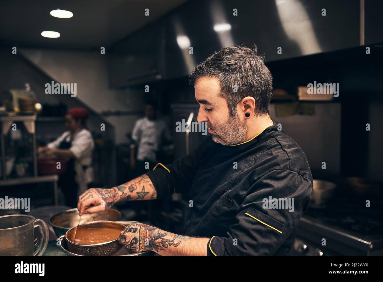 Preparatevi al corso. Shot di uno chef concentrato che prepara un piatto nella cucina di un ristorante. Foto Stock