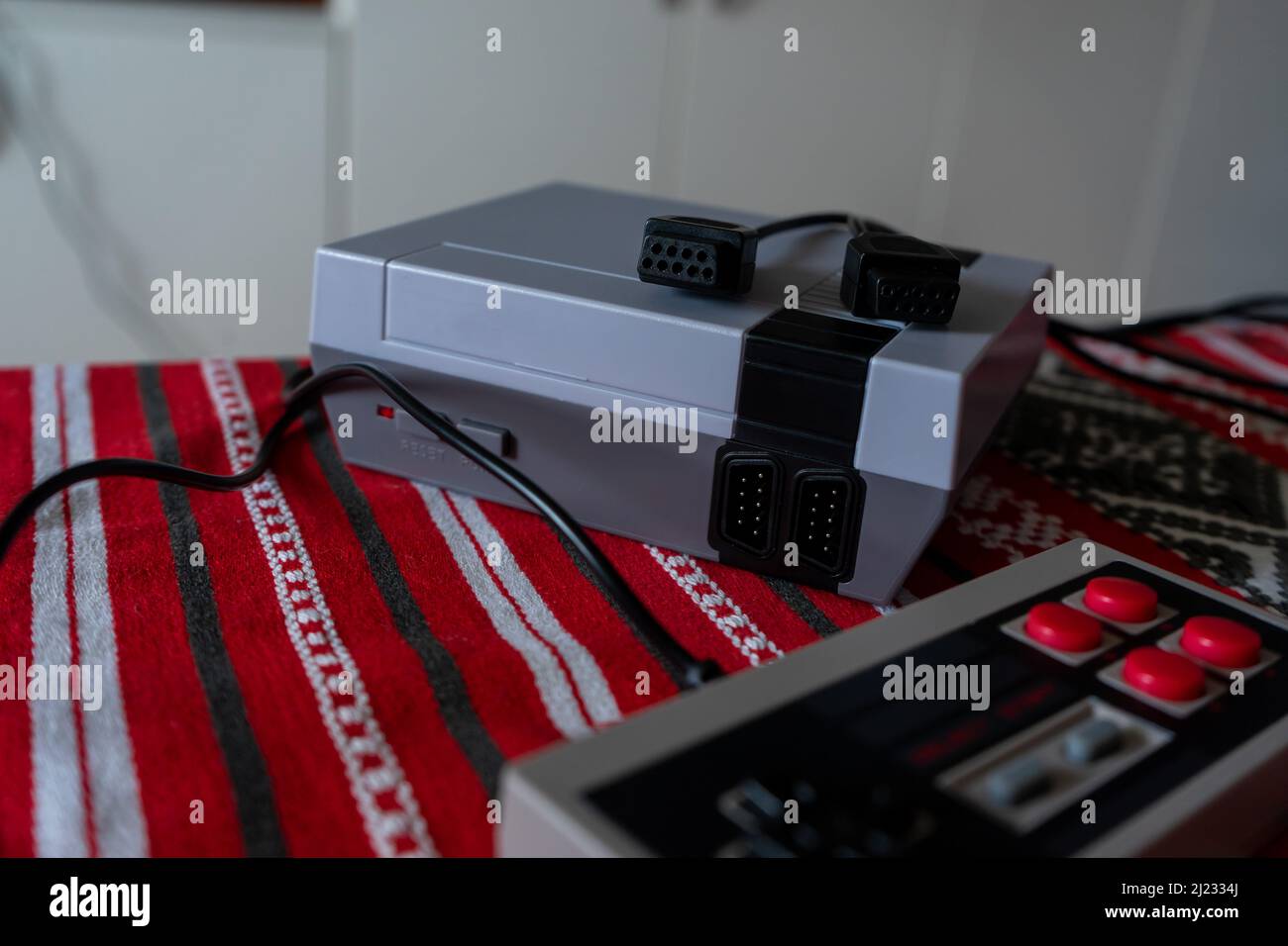 Console di gioco retrò con controller gamepad classico su un tavolo Foto Stock