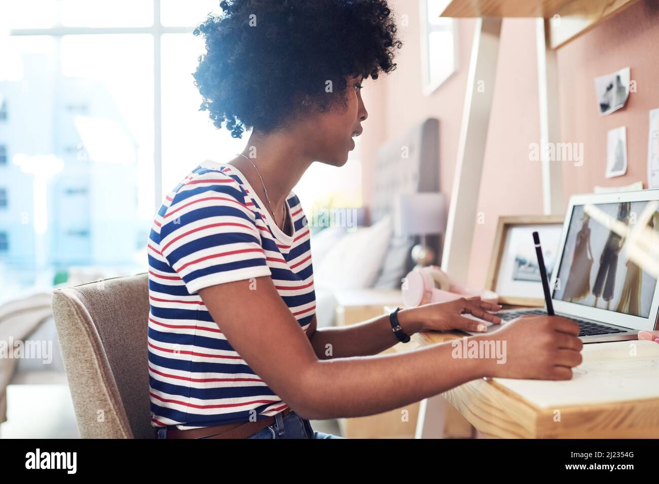 La mia nuova collezione avrà internet ronzio. Scatto corto di una giovane donna che lavora da casa. Foto Stock
