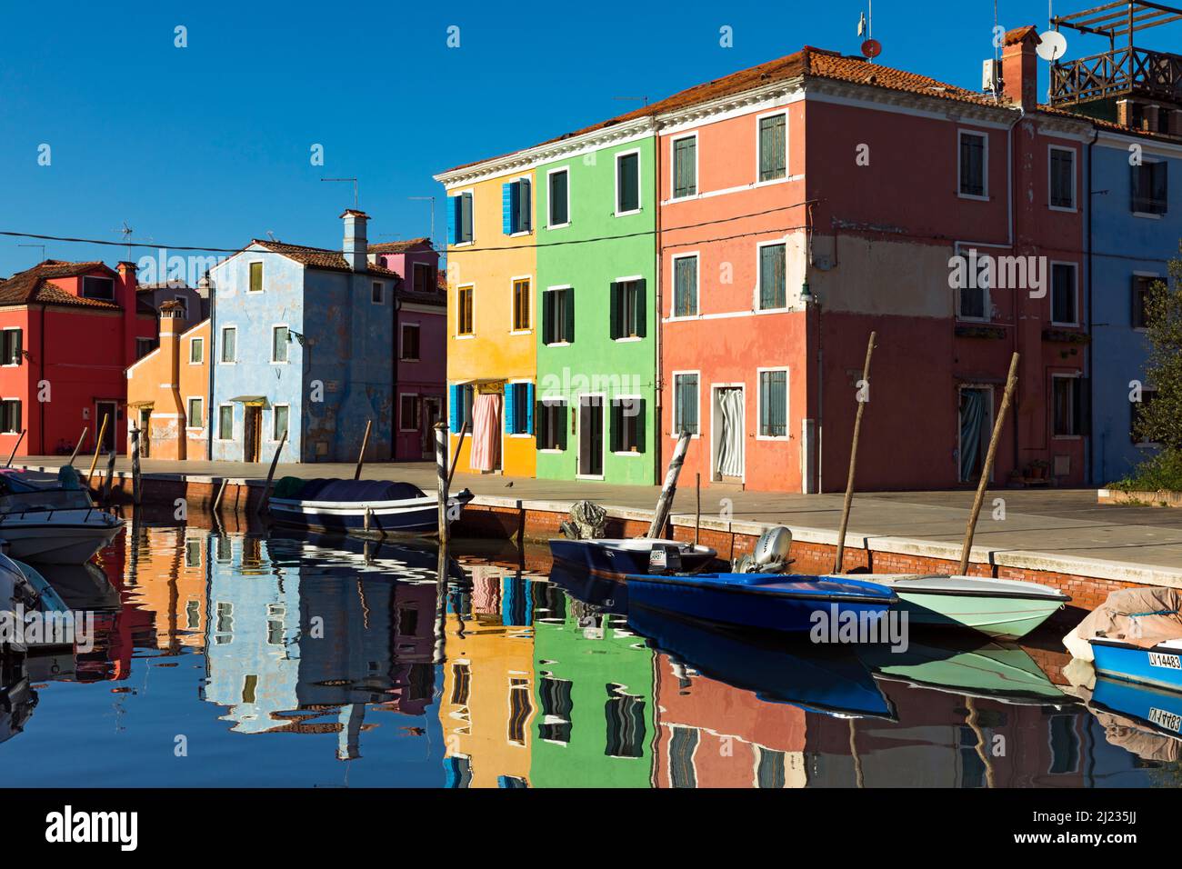 Italia, Venezia, case colorate e negozi su un canale dell'isola veneziana di Burano Foto Stock