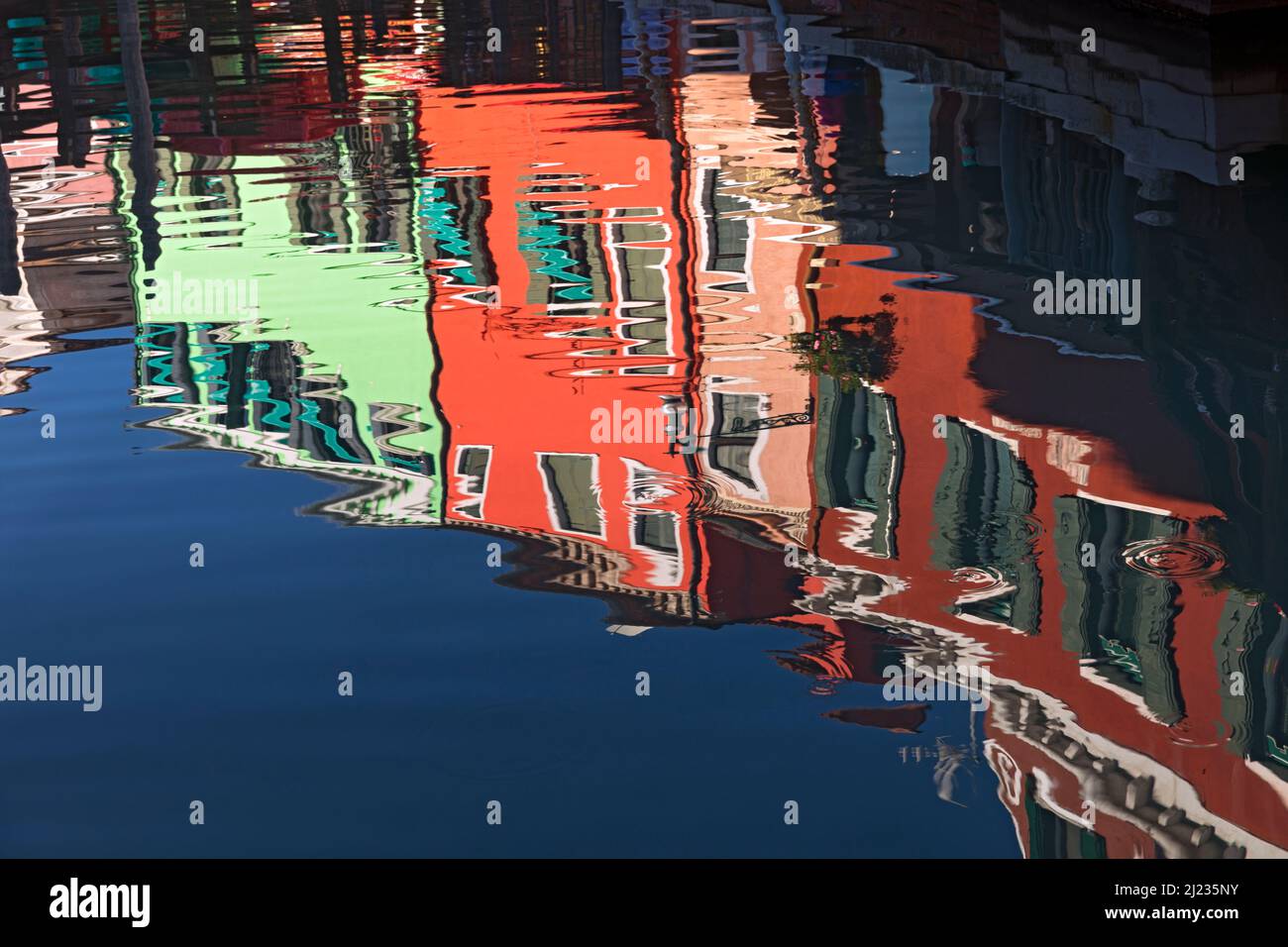 Italia, Venezia, case colorate sull'isola veneziana di Burano che si riflettono su un canale Foto Stock