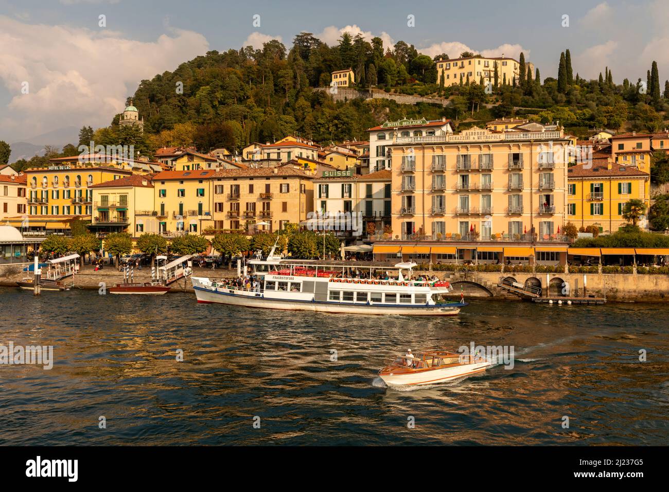 Italia, Lago di Como, Bellagio, il lungomare della città con un traghetto ormeggiato e taxi boat Foto Stock