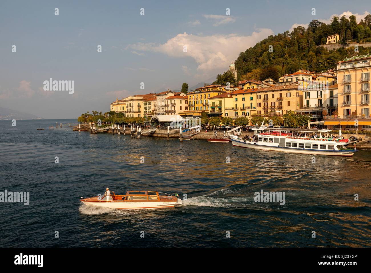 Italia, Lago di Como, Bellagio, il lungomare della città con un traghetto ormeggiato e taxi boat Foto Stock