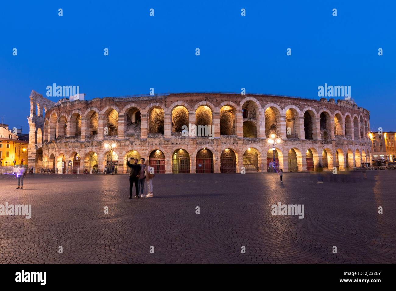 Italia, Verona, l'Arena di Verona, anfiteatro romano al crepuscolo con gente. Foto Stock