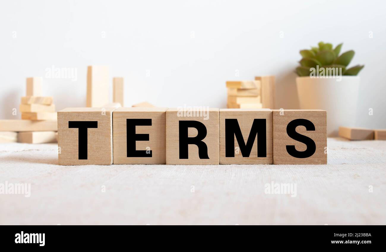 I termini firmano in un ufficio luminoso su una scrivania di legno con le finestre sullo sfondo. Foto Stock