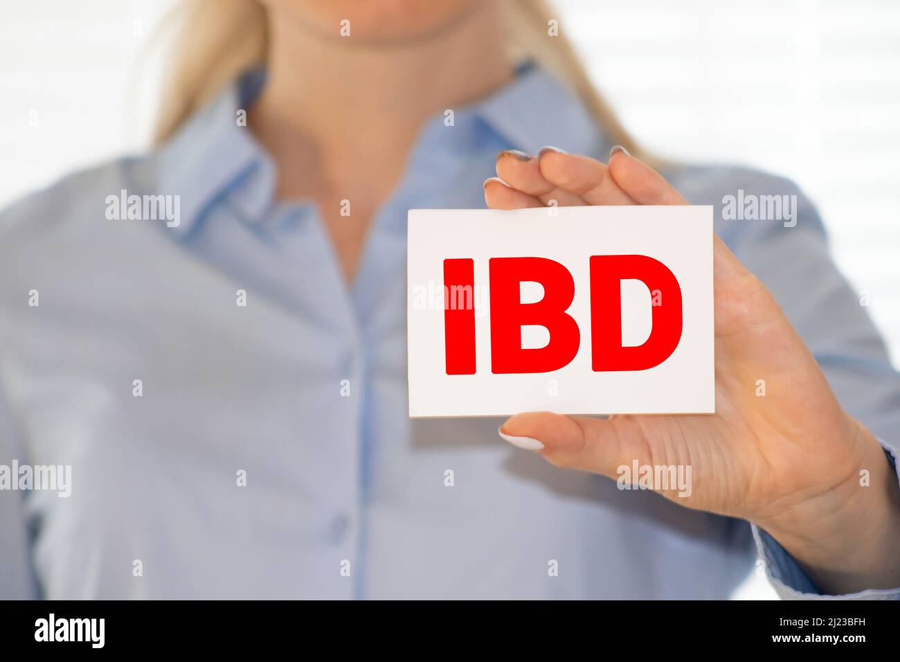 Il medico tiene in mano una carta con l'abbreviazione IBD. Foto Stock
