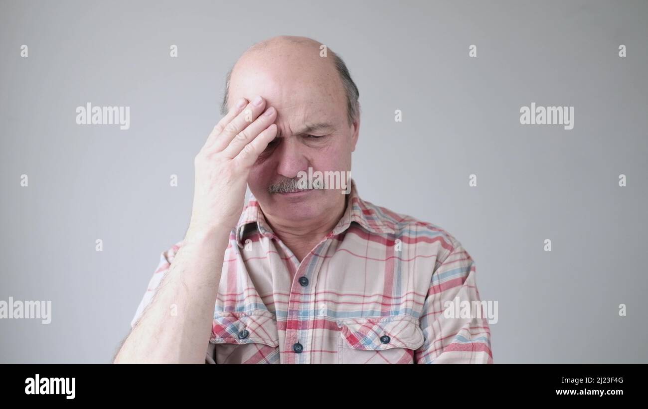 Uomo ispanico senior che cerca di ricordare qualcosa o avere mal di testa terribile. Foto studio Foto Stock